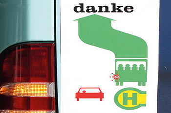 Bus mit Warnblinklicht und Hinweisschild